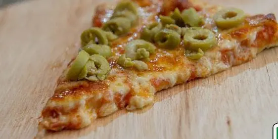 Porción de pizza con aceitunas verdes sobre tabla