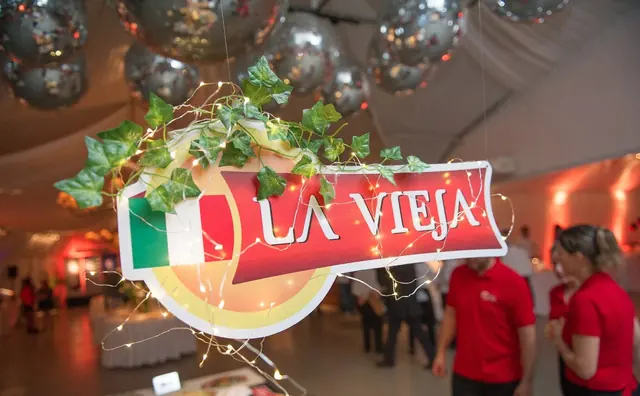 Cartel de La Vieja con la bandera de Italia en el stand del evento