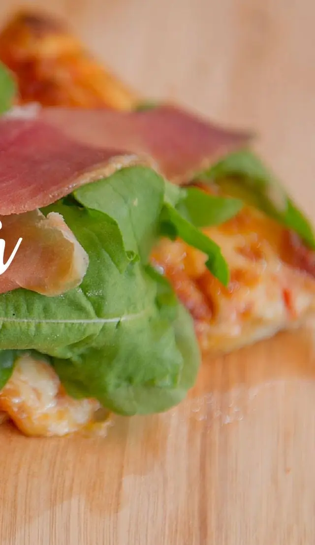 Porción de pizza Rústica con rúcula y jamón crudo